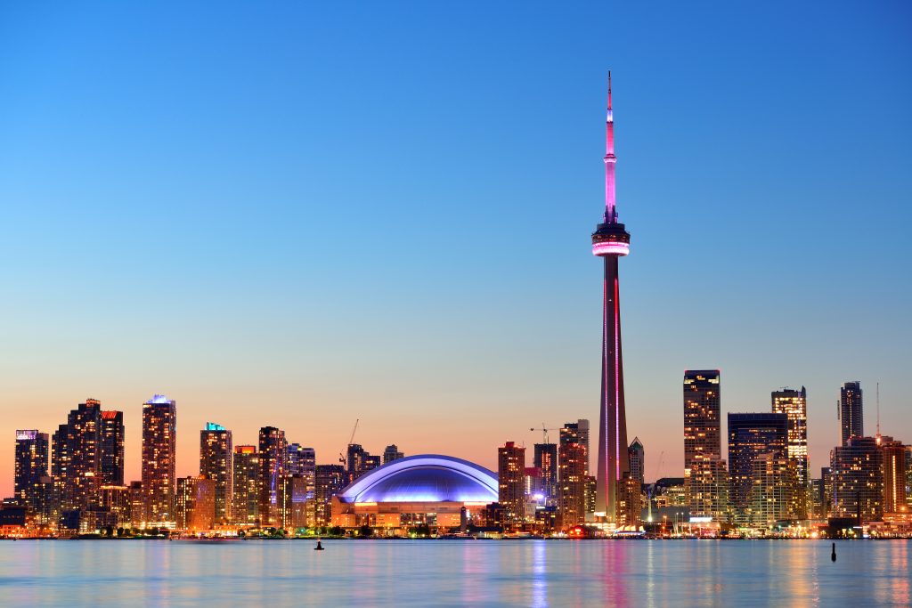 Toronto sunset over lake panorama with urban skyline. Toronto is one of the cheapest destinations to travel to.